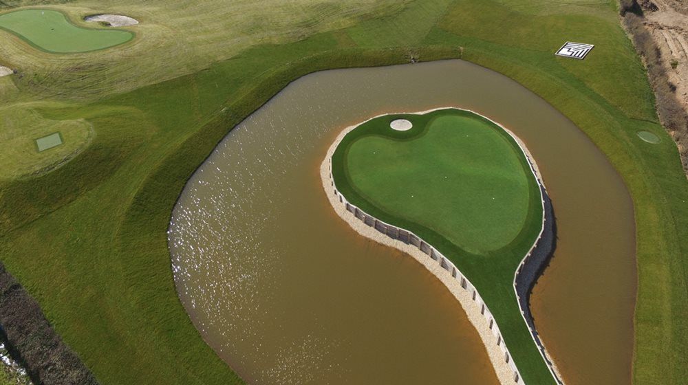 Los Angeles and Southern California Aerial view of a vibrant green synthetic grass island in a natural pond on a golf course