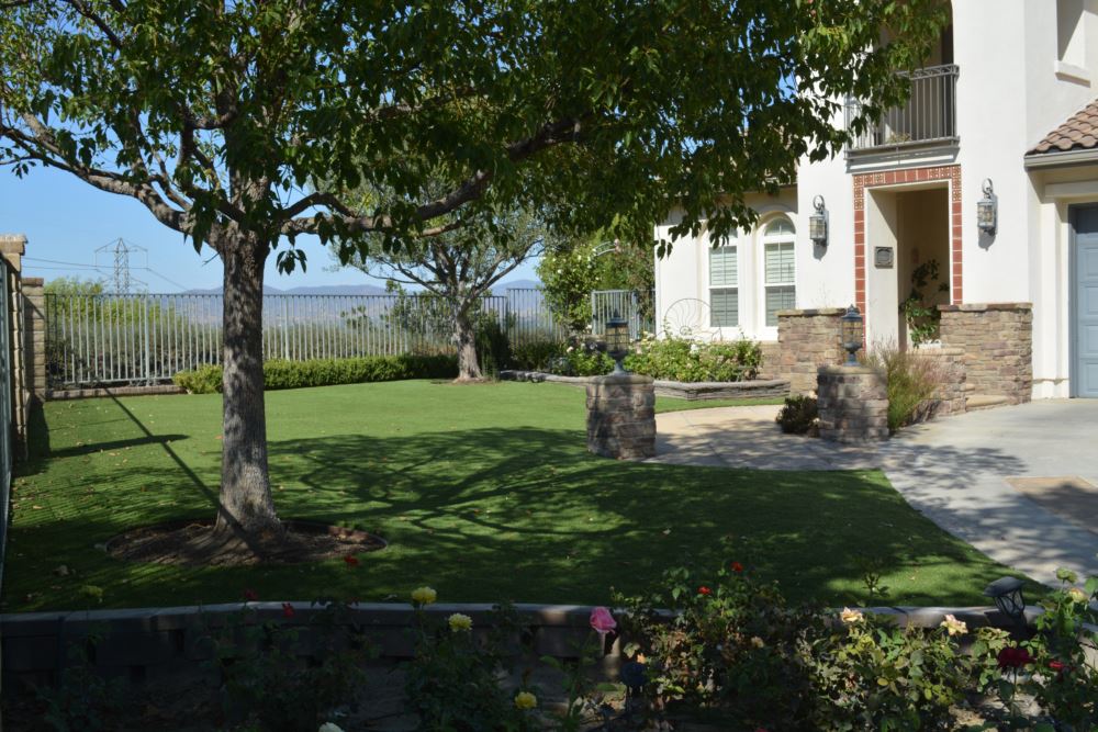 Side yard putting green turf with stone columns and mountain view fencing